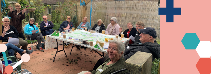 A group of older adults around a table in a garden. Members of the Stevenage Dementia Involvement Group