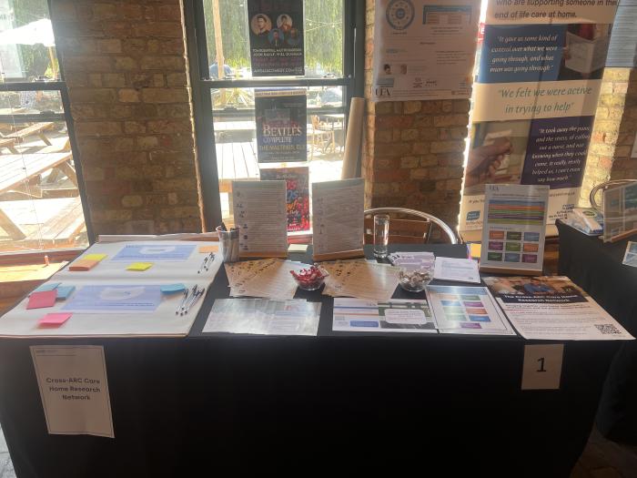 Research stall featuring information about the Cross-ARC Care Home Research Network and palliative care studies at the launch event