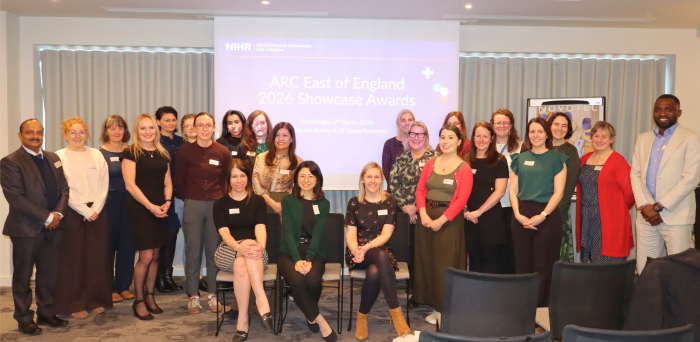 The 14th cohort of Research and Impact Fellows all together smiling at the camera